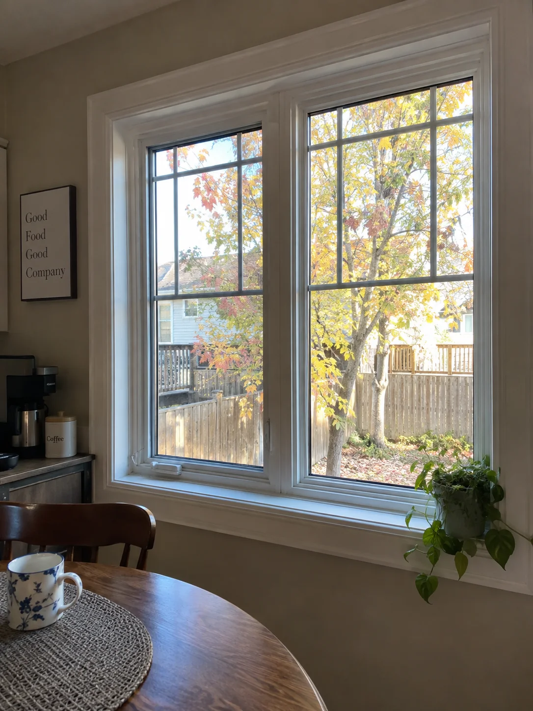 White windows viewed from a lived-in kitchen breakfast corner